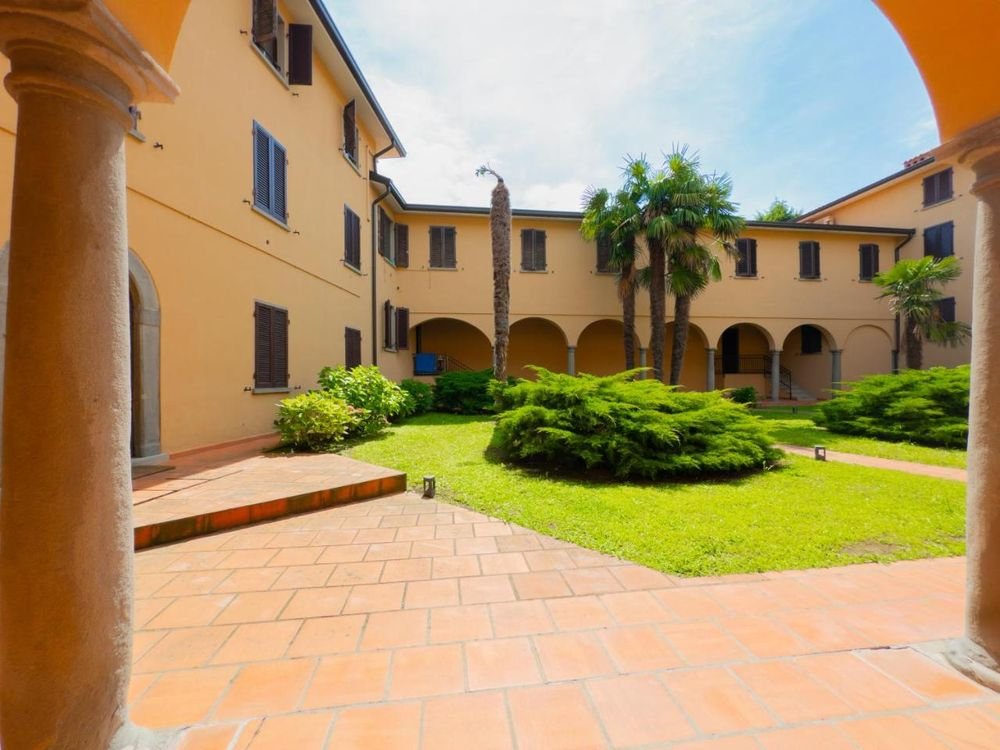 Corte interna della residenza con portico ad archi e giardino