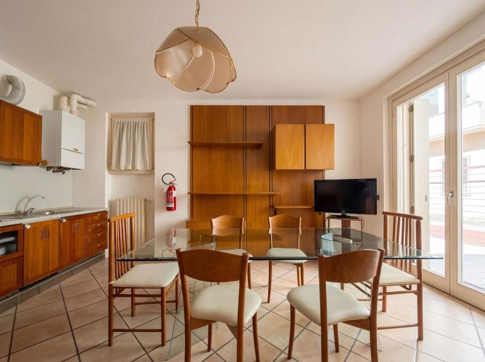 Zona pranzo con TV e porta-finestra sulla terrazza