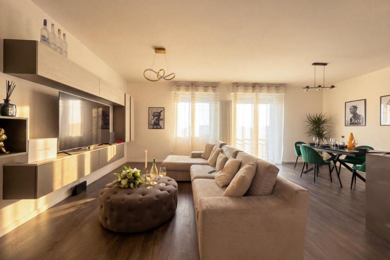 Großzügiges Wohnzimmer des Design Penthouse in Iseo mit Sofa, petrolfarbener Wand und Essbereich
