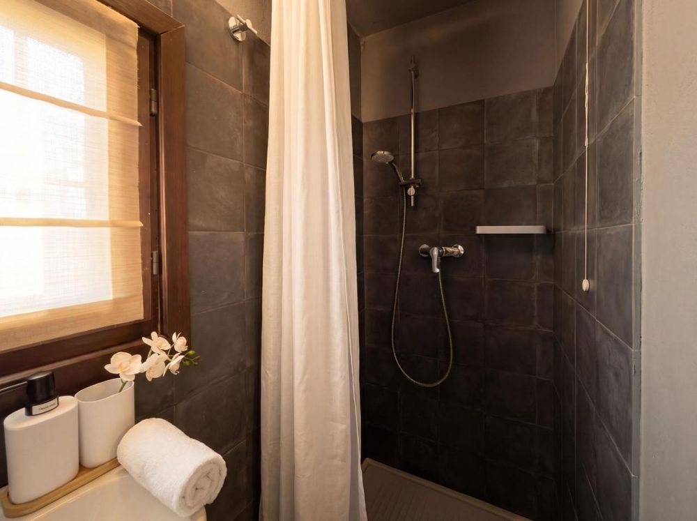 Bad mit Dusche und anthrazitfarbenen Fliesen
