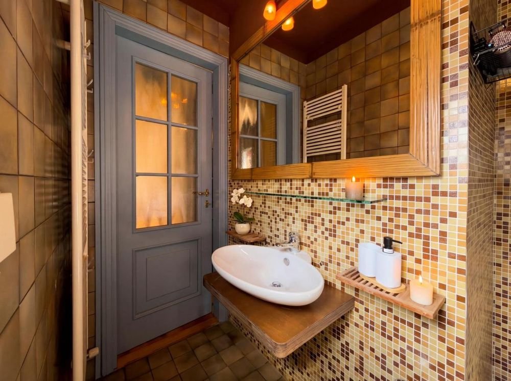 Mit Mosaik gefliestes Bad mit Aufsatzwaschbecken
