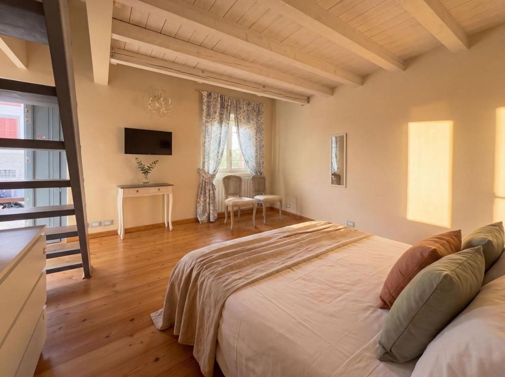 Doppelzimmer im Dachgeschoss mit TV und hölzernem Zwischengeschoss