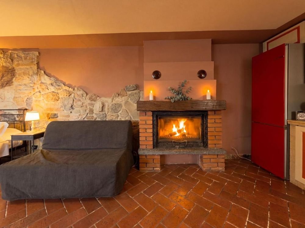 Brennender Kamin in der Erdgeschosswohnung mit Natursteinwand