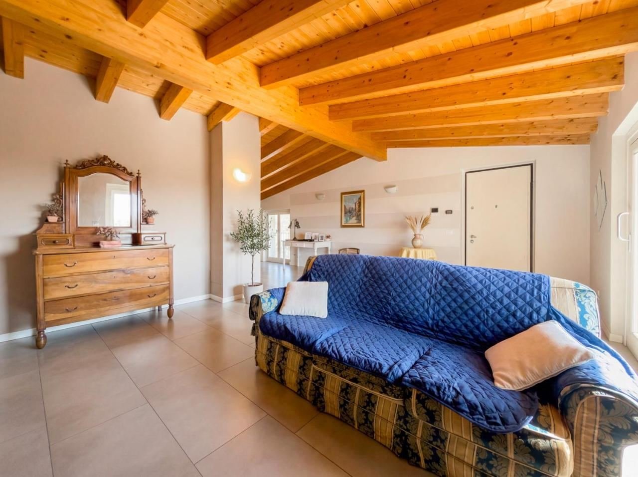 Large, bright living room with a sofa and a wooden ceiling