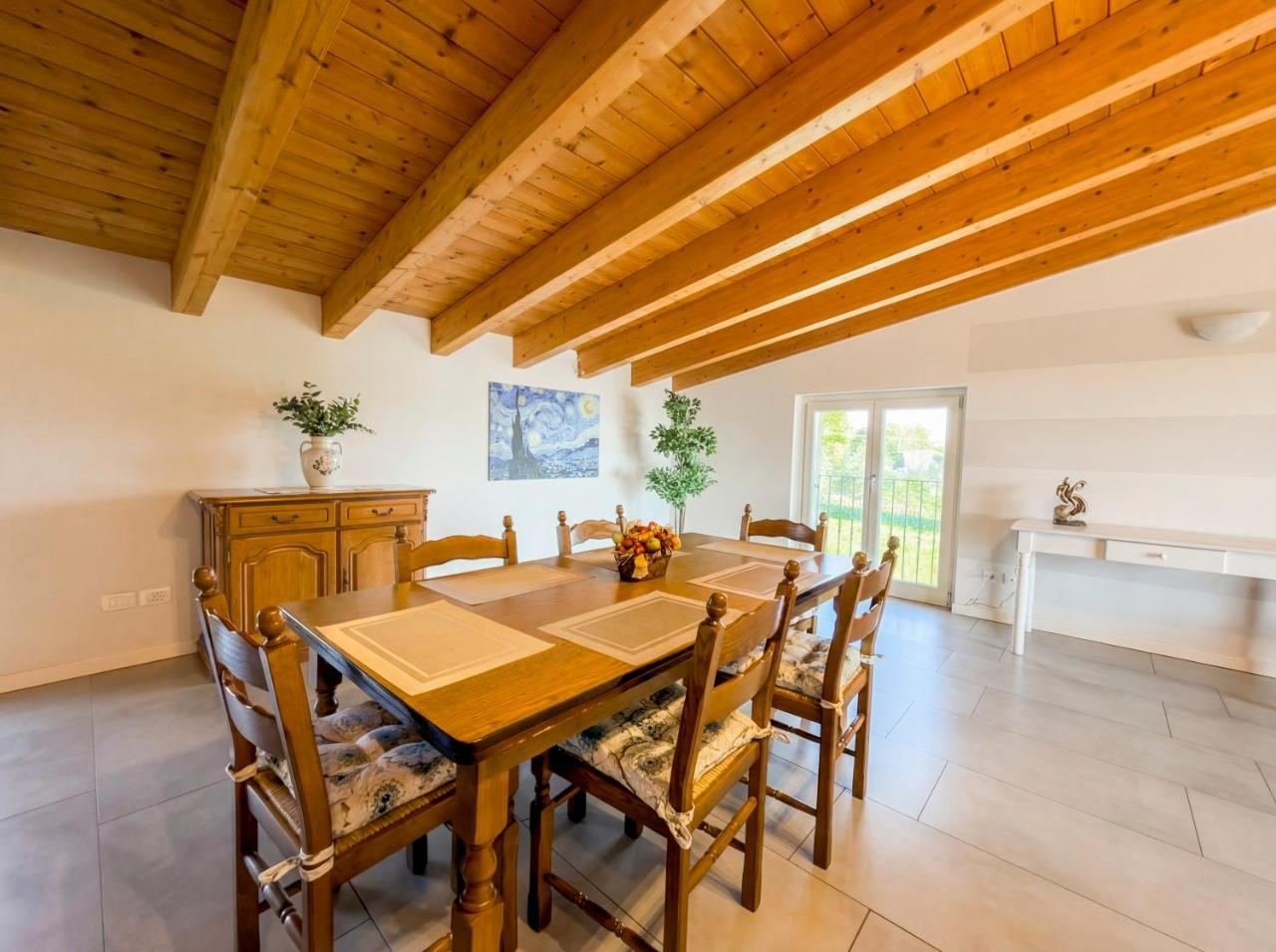 Dining area of the loft with a wooden table under exposed beam ceilings