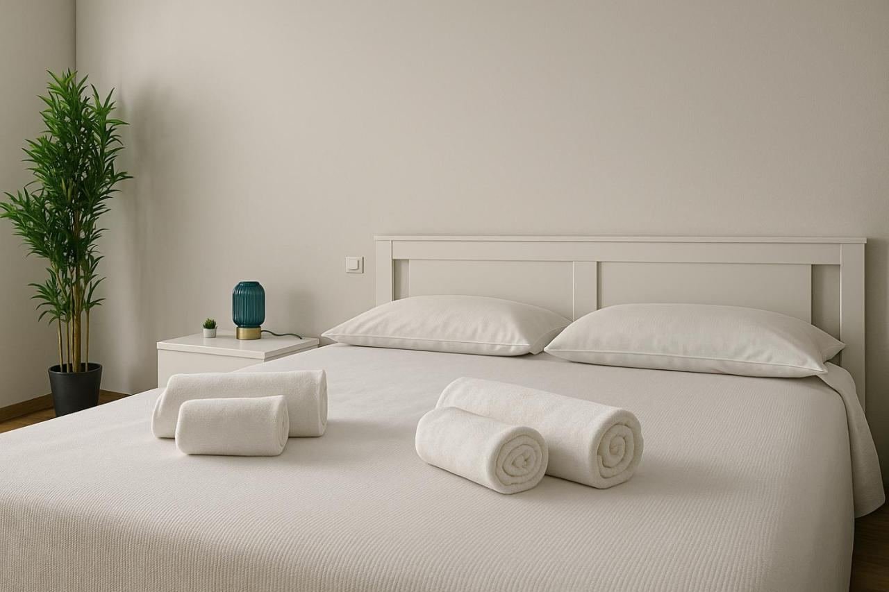 Letto matrimoniale con biancheria fresca e piante nel monolocale
