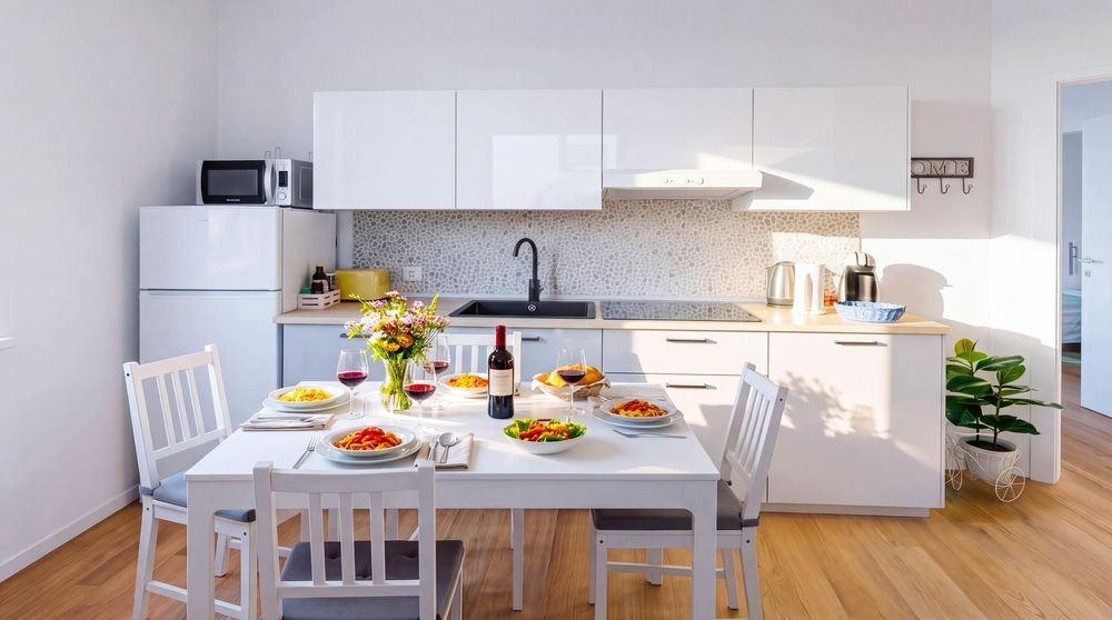 Cucina attrezzata con piano cottura, forno e tavolo da pranzo