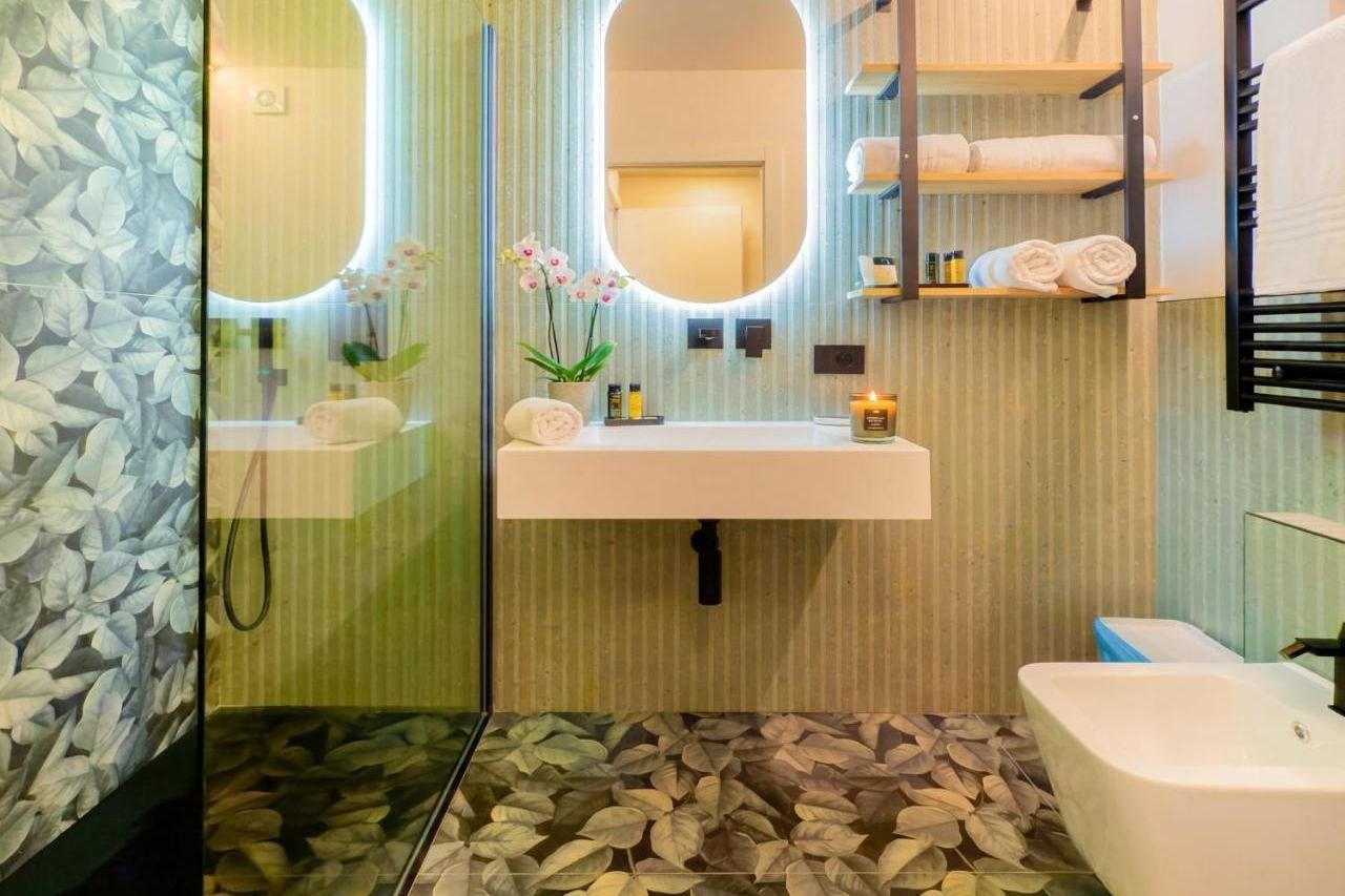 Bagno di design con doccia walk-in e rivestimento botanico verde