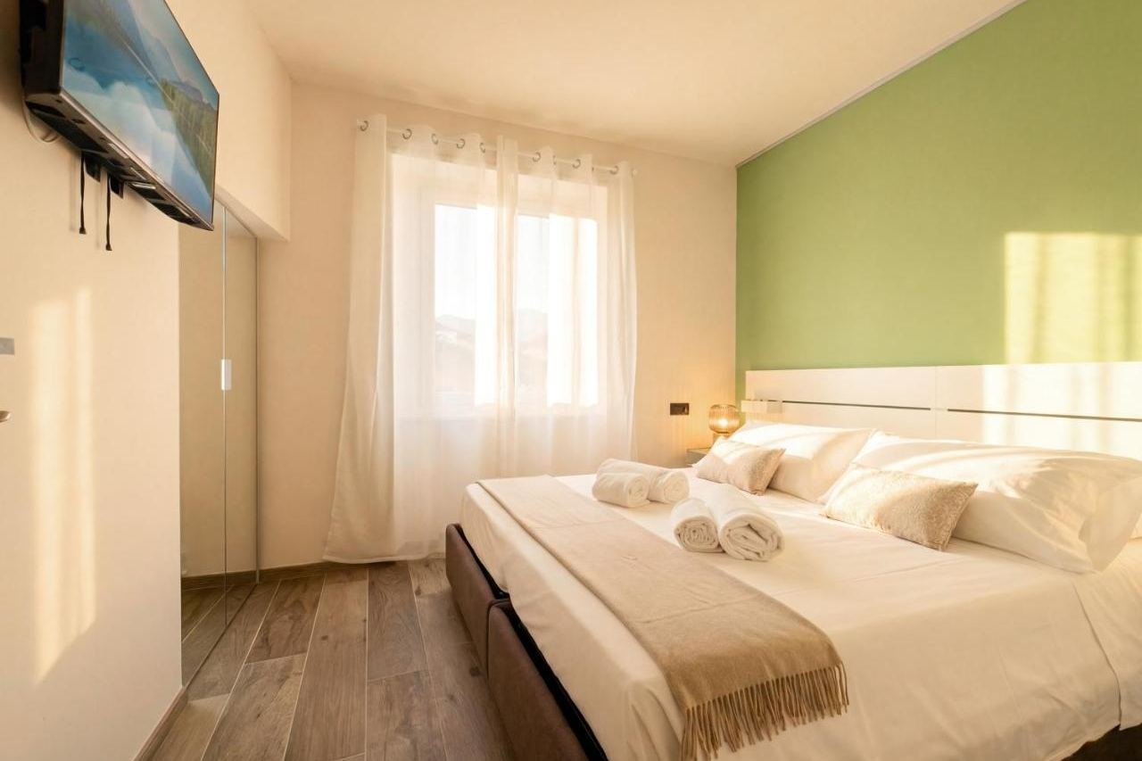 Seconda camera matrimoniale con parete verde e Smart TV