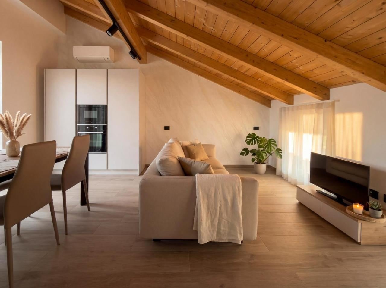 Living room of the Penthouse Apartment with a sofa and exposed wooden beams