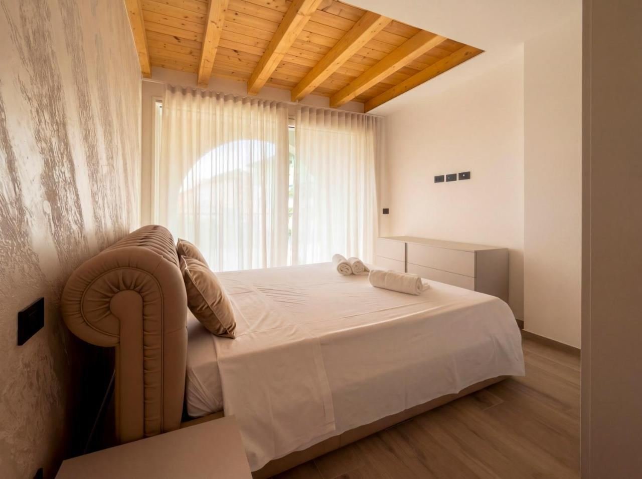 Double bedroom of the penthouse with a tufted headboard