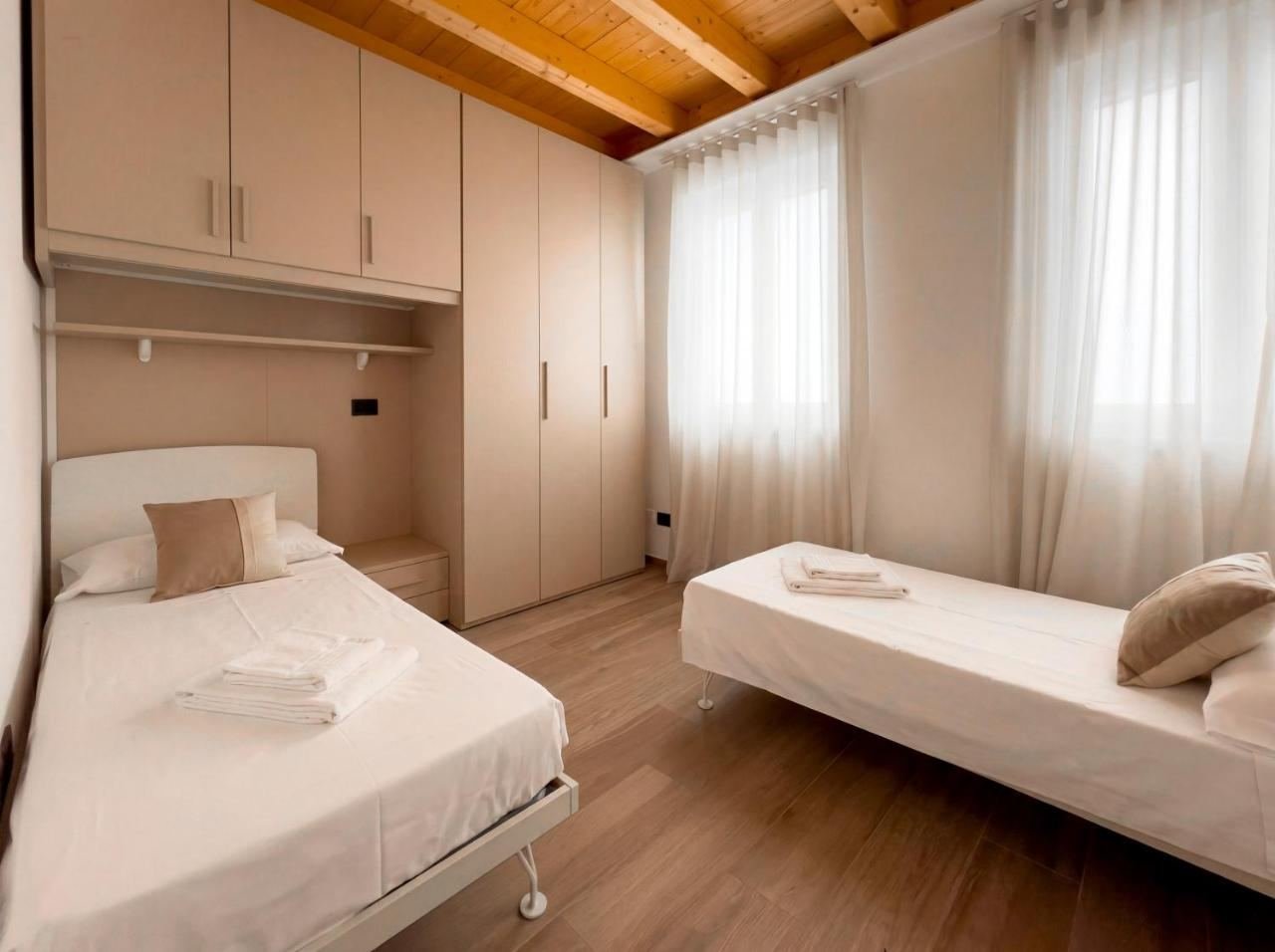 Second bedroom of the penthouse with two single beds under the wooden roof