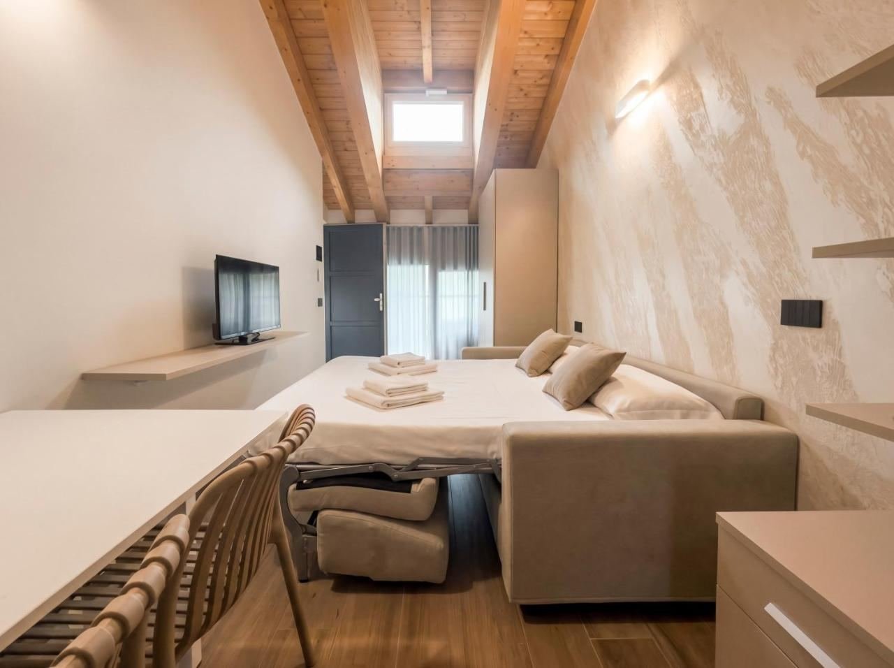 Monolocale 11: divano letto aperto sotto il tetto in legno