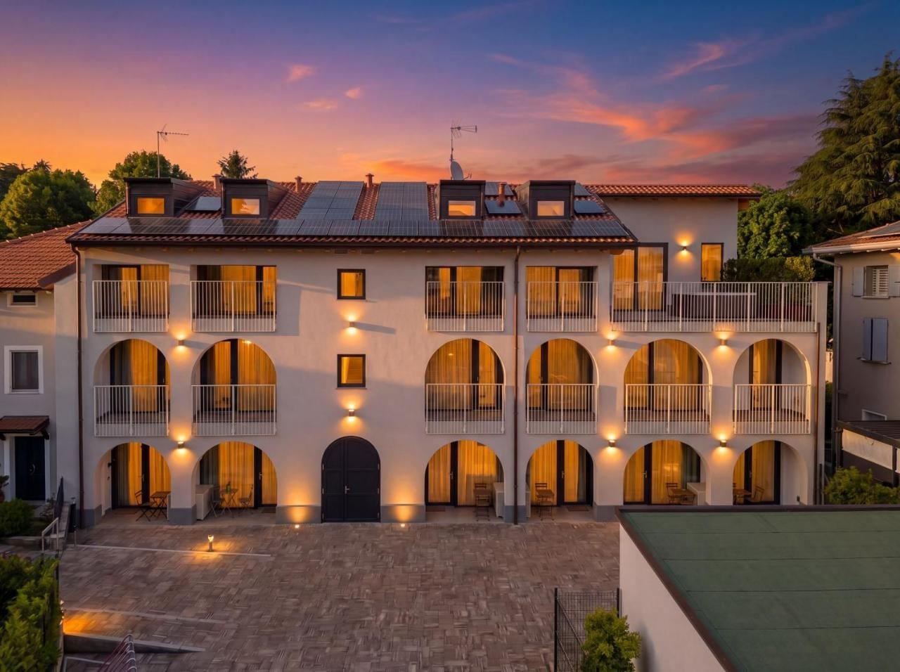 Facade of the Lake Iseo Apartments & Suites residence in Paratico, lit up at sunset