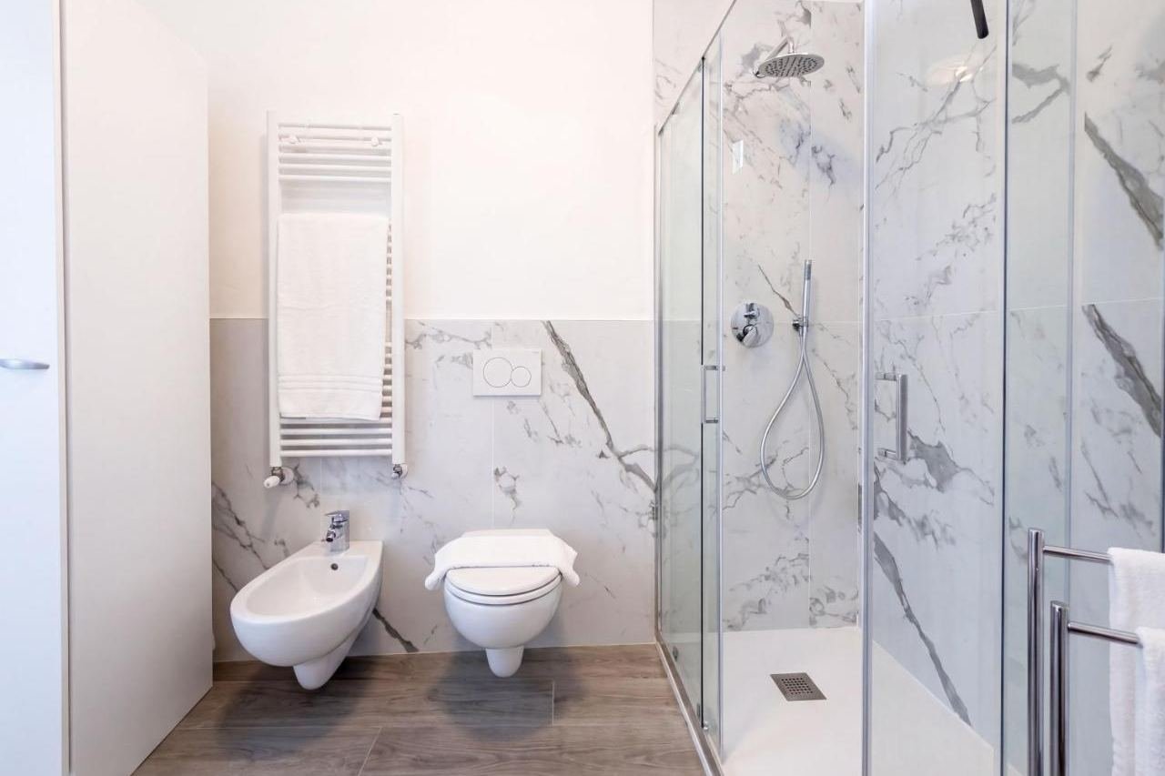 White marble shower and bidet in the Deluxe apartment bathroom