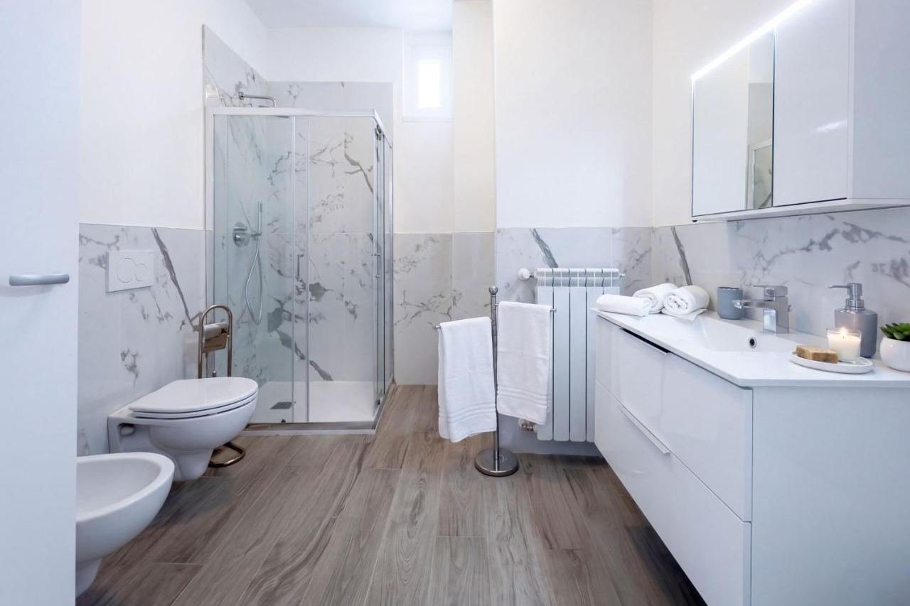 Bathroom of the Deluxe apartment clad in Carrara marble with shower and bidet