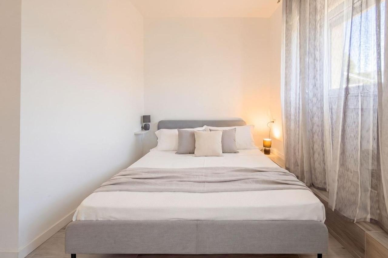 Double bedroom of the Deluxe apartment with warm light and wardrobe