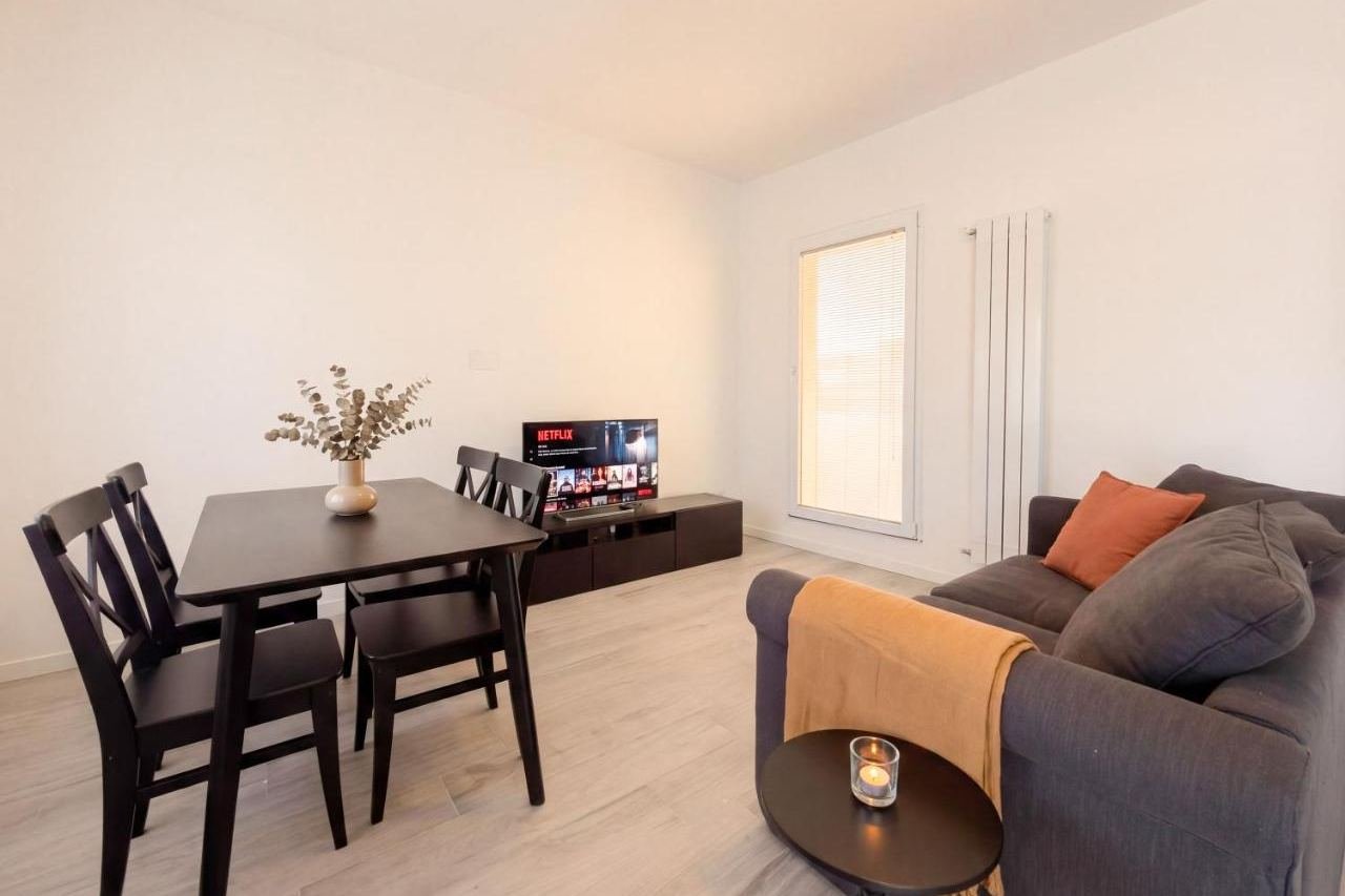 Dining area of the Deluxe apartment with table, sofa and Smart TV