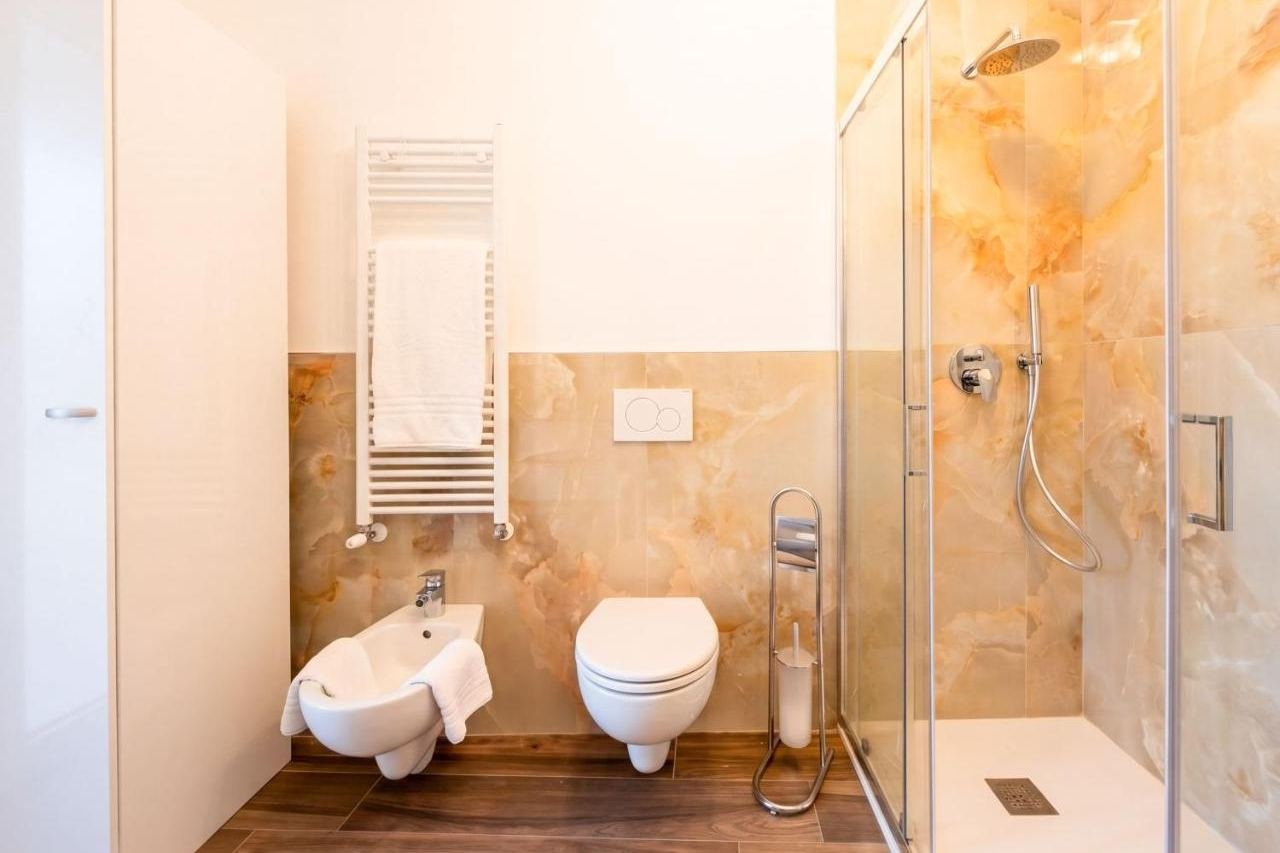Golden marble shower and bidet in the Superior apartment bathroom