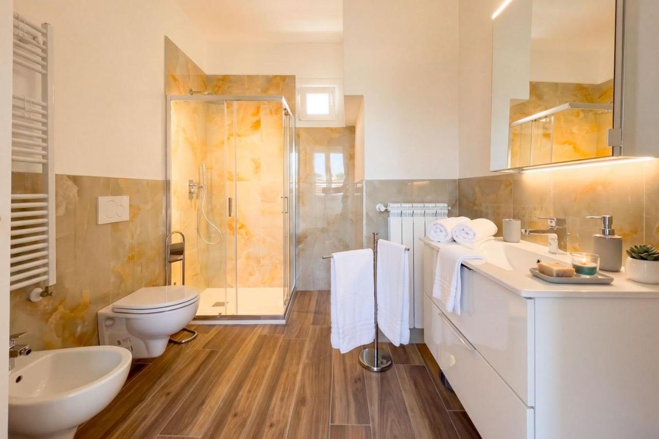 Bathroom of the Superior apartment clad in golden marble with shower and bidet