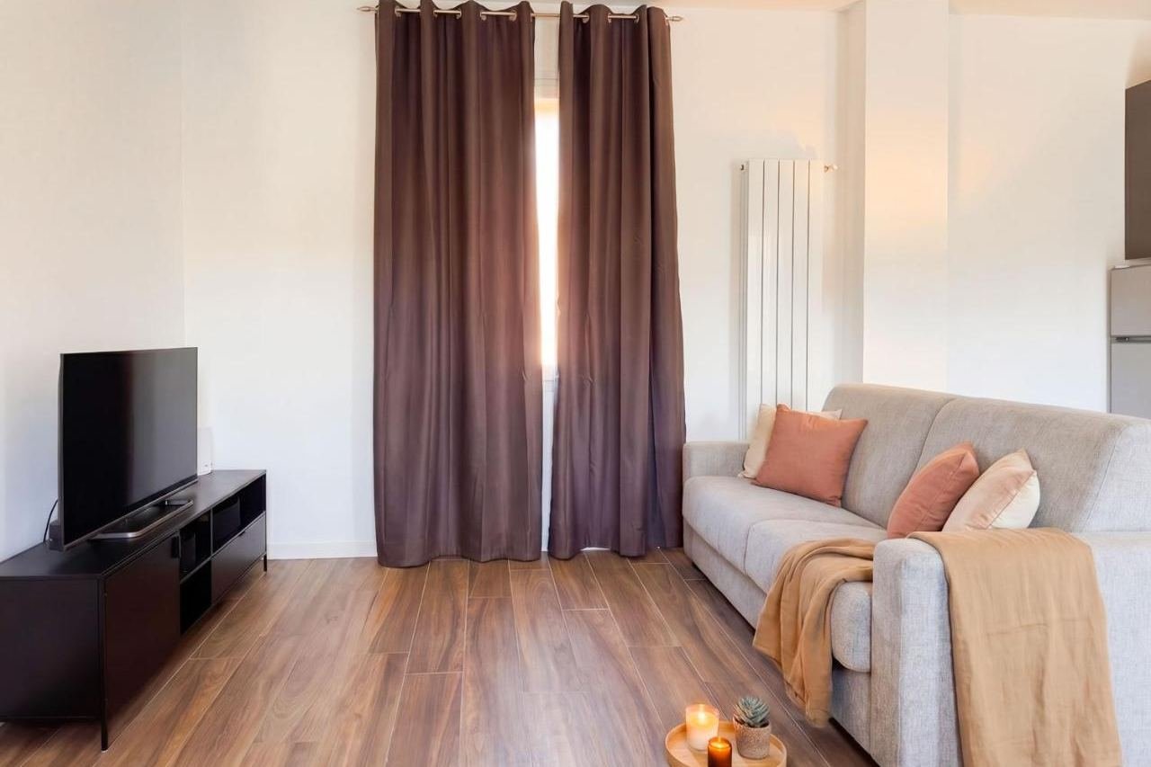 Sitting area of the Superior apartment with sofa, Smart TV and warm curtains