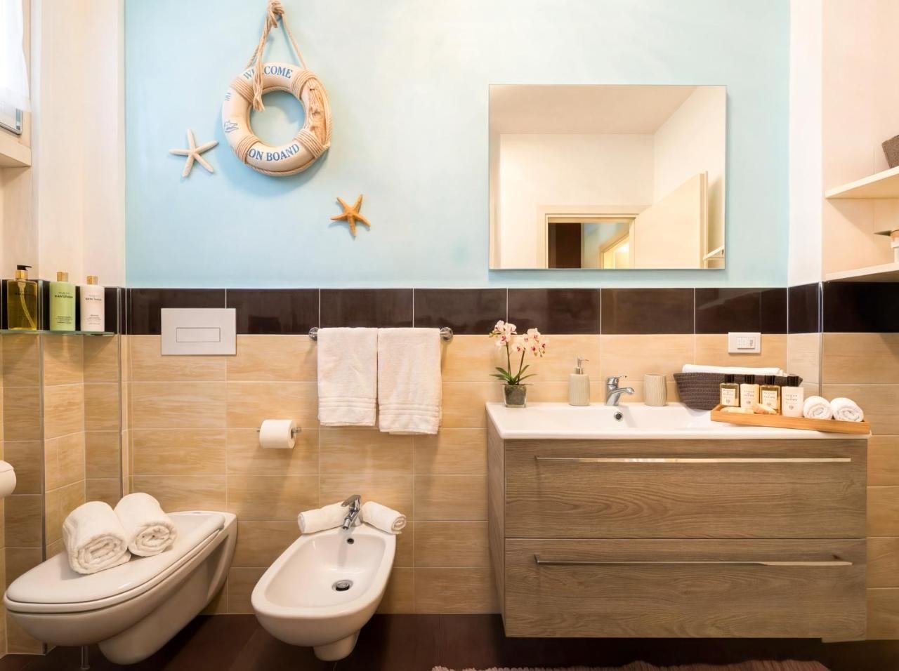 Badezimmer mit Waschbecken, Bidet und Spiegel in hellen Tönen