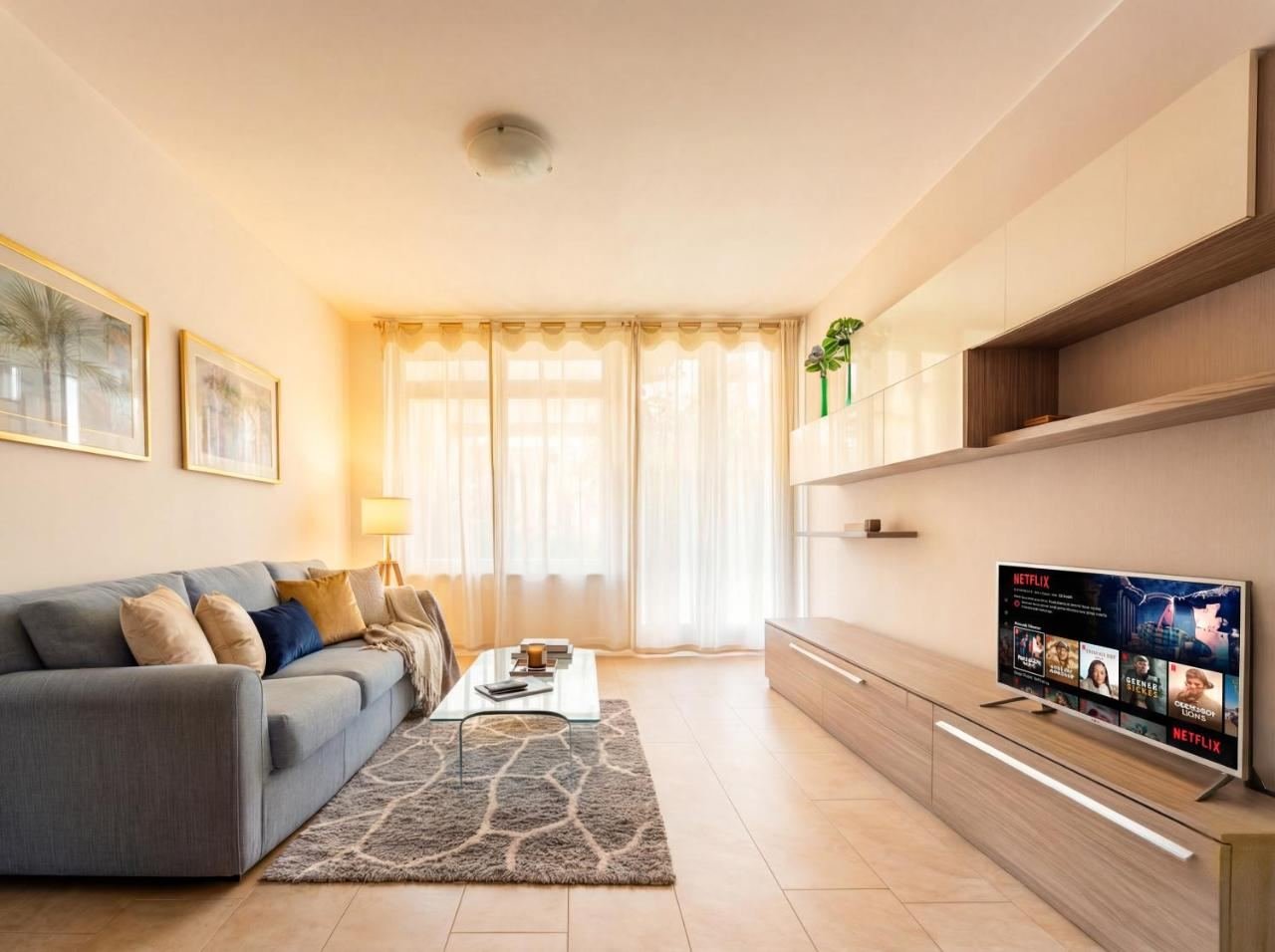 Helles Wohnzimmer mit Sofa und Smart-TV, offen zum Wohnbereich
