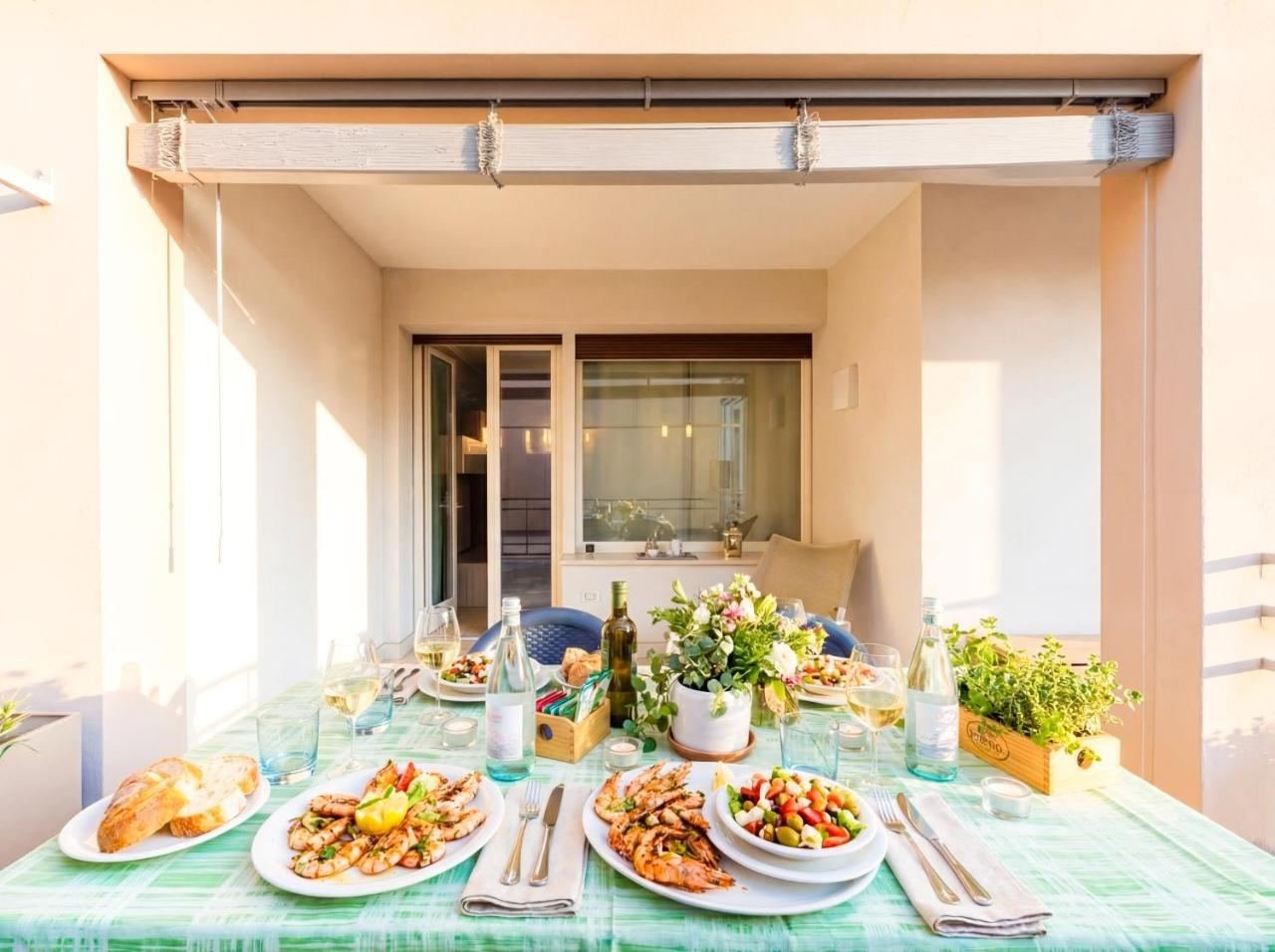 Terrasse mit gedecktem Tisch unter der Markise, bereit zum Essen im Freien