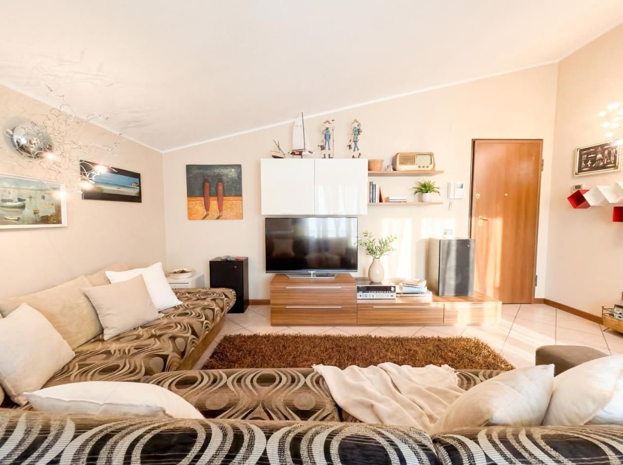 Helles Wohnzimmer des Penthouses mit Sofa und Smart-TV