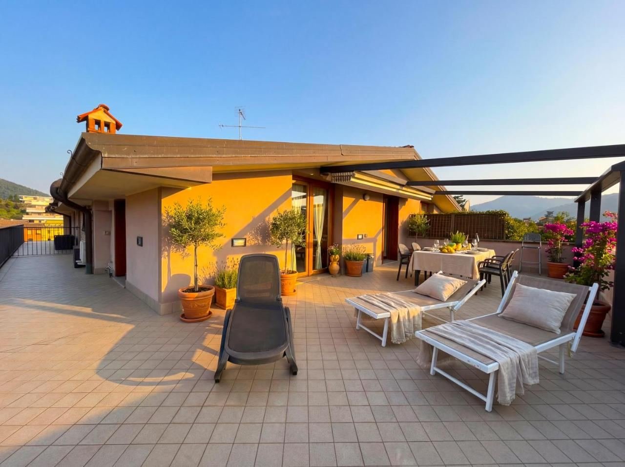 Terrasse des Penthouses bei Sonnenuntergang, mit Sonnenliegen