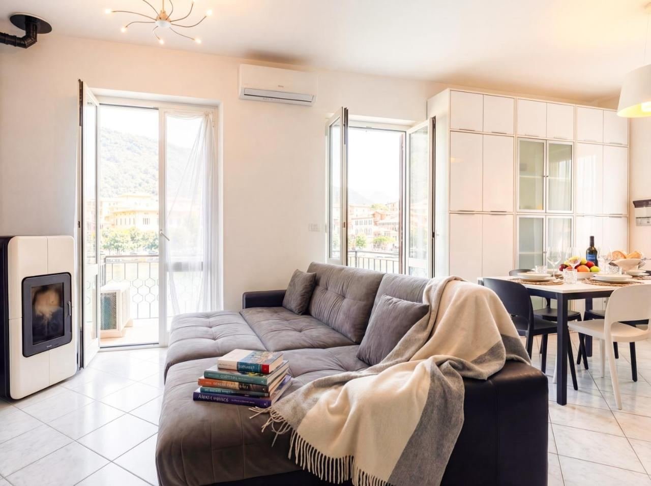 Living room with a corner sofa and a stove, open to the dining area