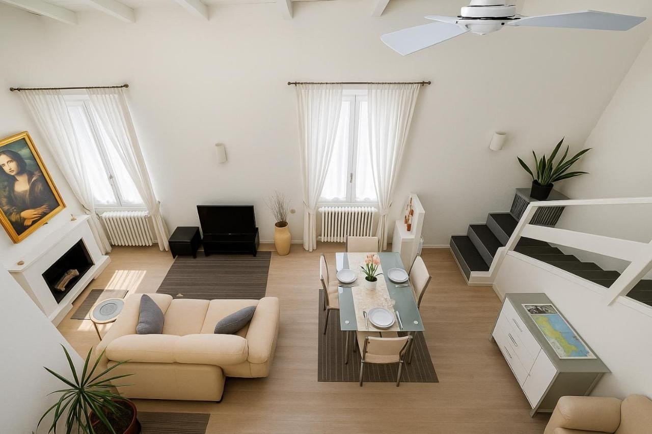 Großes Wohnzimmer von La Corte del Castello in Iseo mit Sofa, Kamin, Essbereich und Treppe zur Galerie