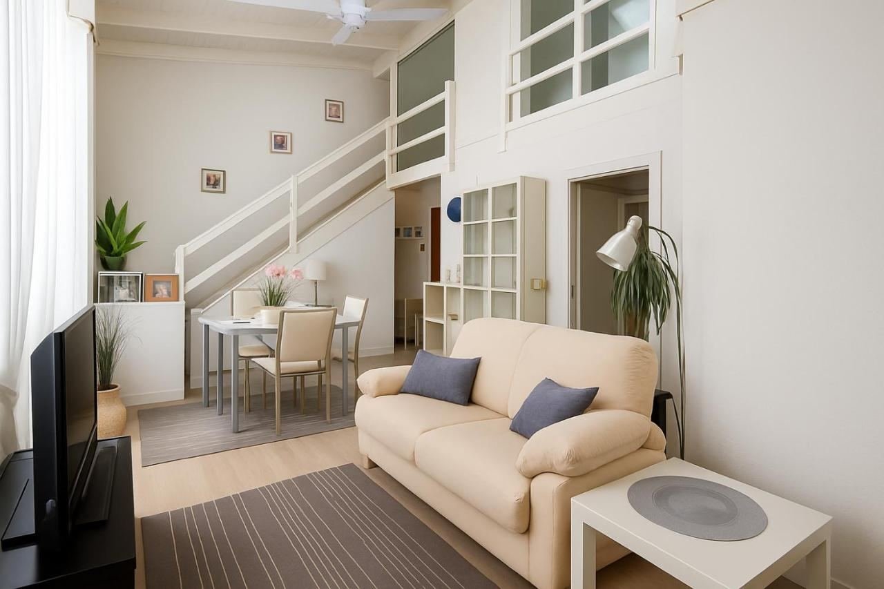 Wohnzimmer mit Treppe zur Galerie, Sofa und Smart-TV