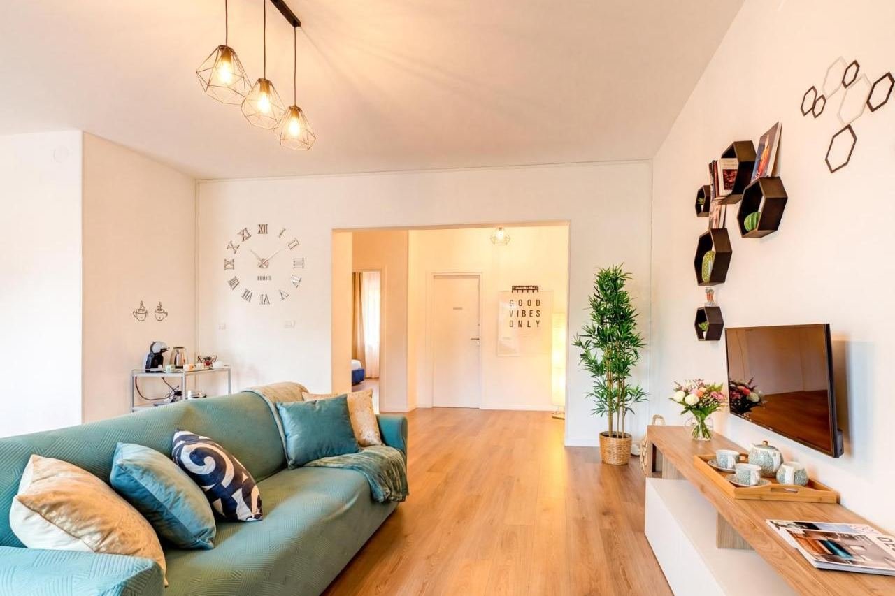 Helles Wohnzimmer mit hellblauem Sofa, TV und Fenstertür