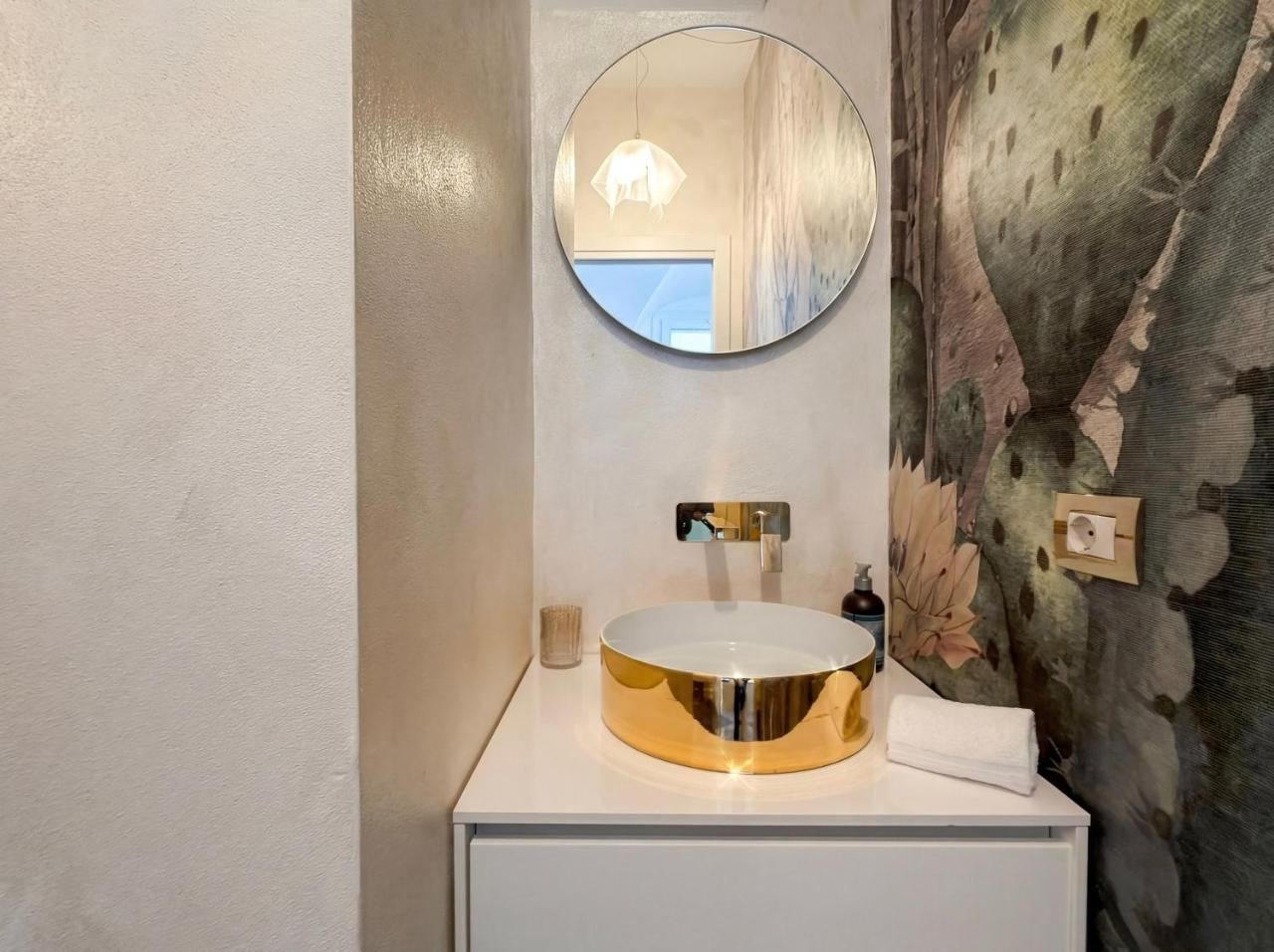 Bad mit goldenem Aufsatzwaschbecken und dekorierter Wand