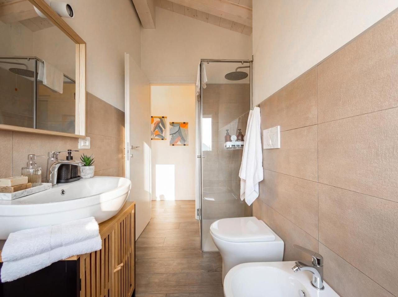 Main bathroom with a shower, basin and bidet, light tiles