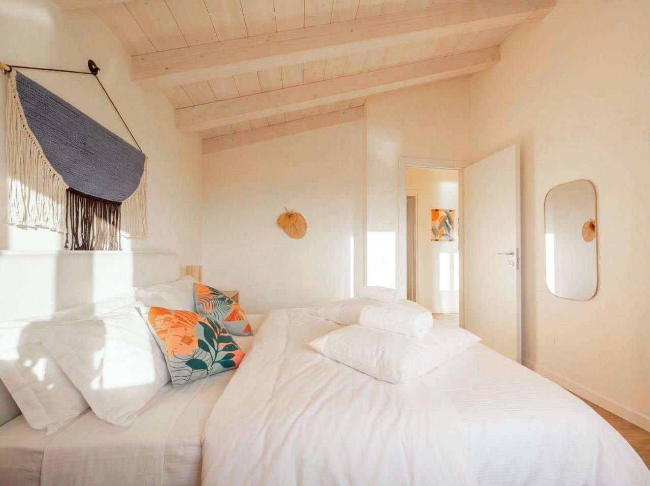 Second double bedroom with orange cushions and a panoramic window
