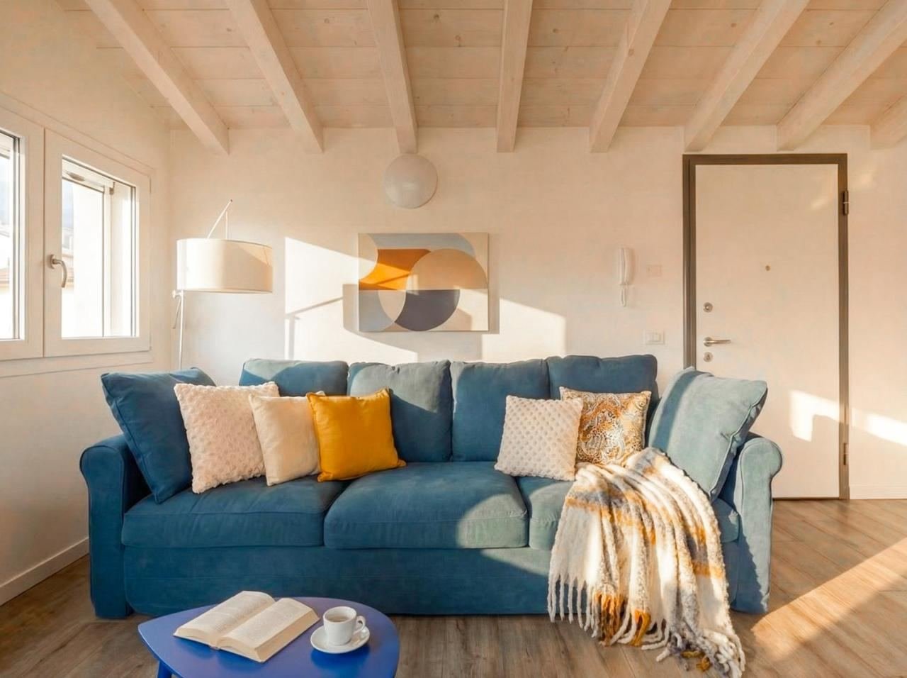 Bright living corner with a light-blue sofa and colourful cushions