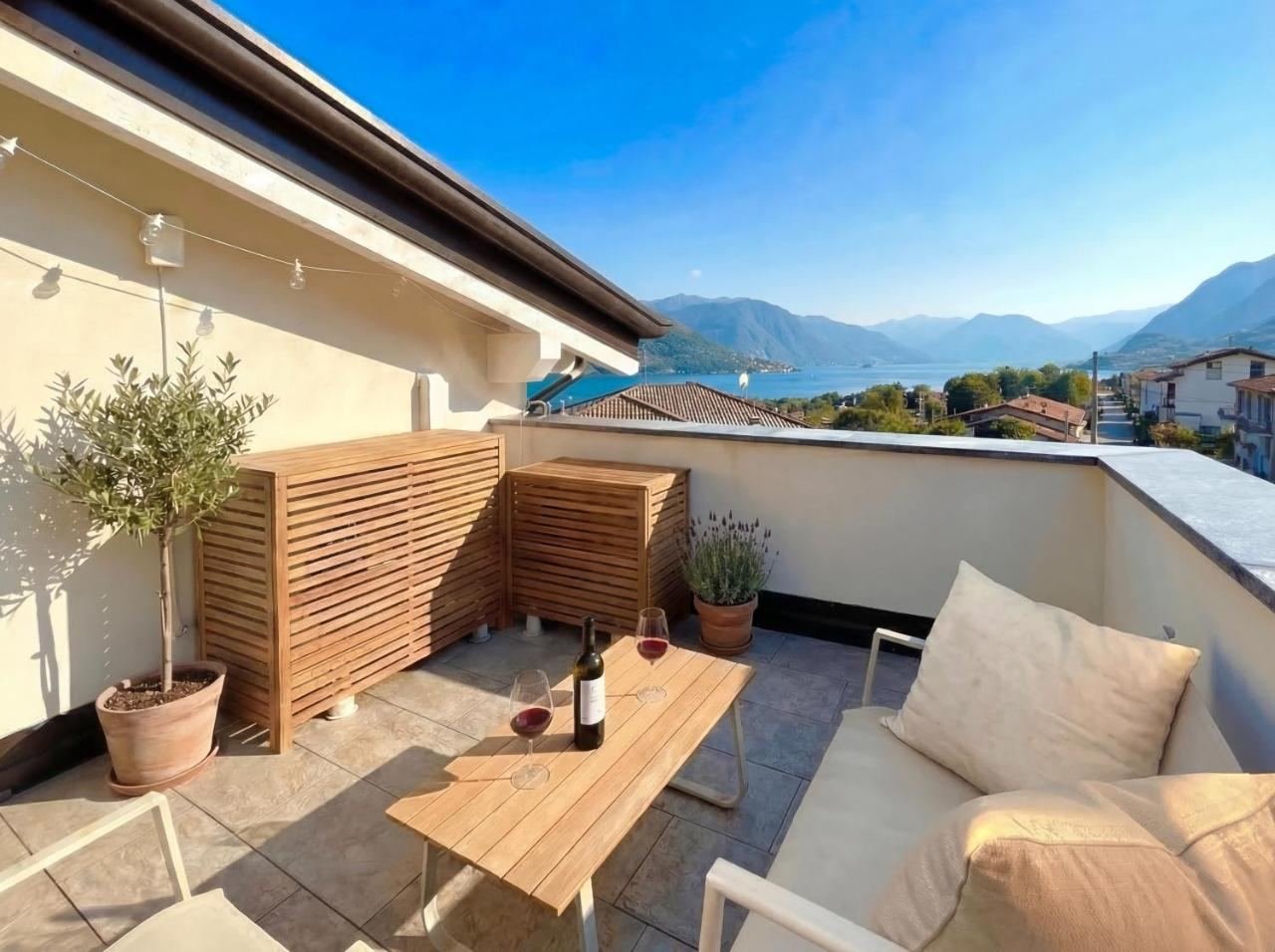 Terrace with a wooden screen, table and views over the lake and mountains by day